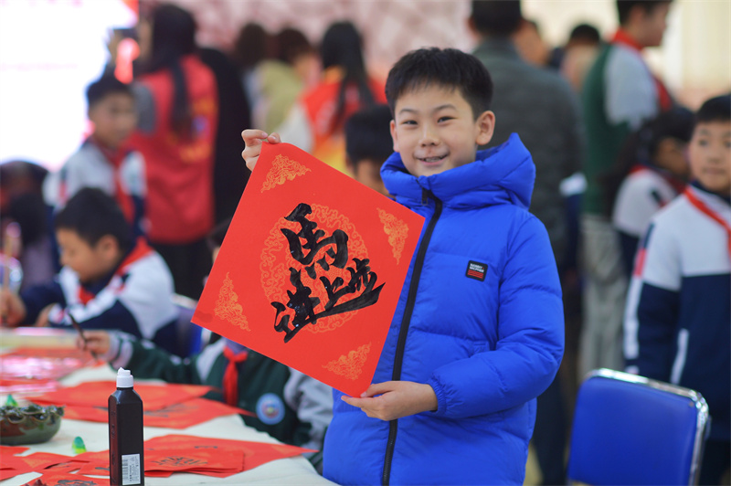 2026年1月29日，在山東省青島市市北區重慶路第三小學舉辦的“萬福迎春”書法活動上，一名學生展示書寫的“馬上進步”。
