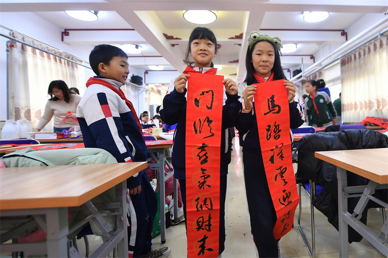 2026年1月29日，在山東省青島市市北區重慶路第三小學舉辦的“萬福迎春”書法活動上，兩名學生去擺放寫好的對聯。