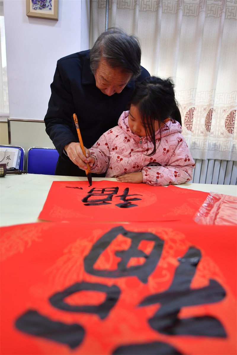 2026年1月29日，在山東省青島市市北區重慶路第三小學舉辦的“萬福迎春”書法活動上，書法家在指導學生書寫要領。