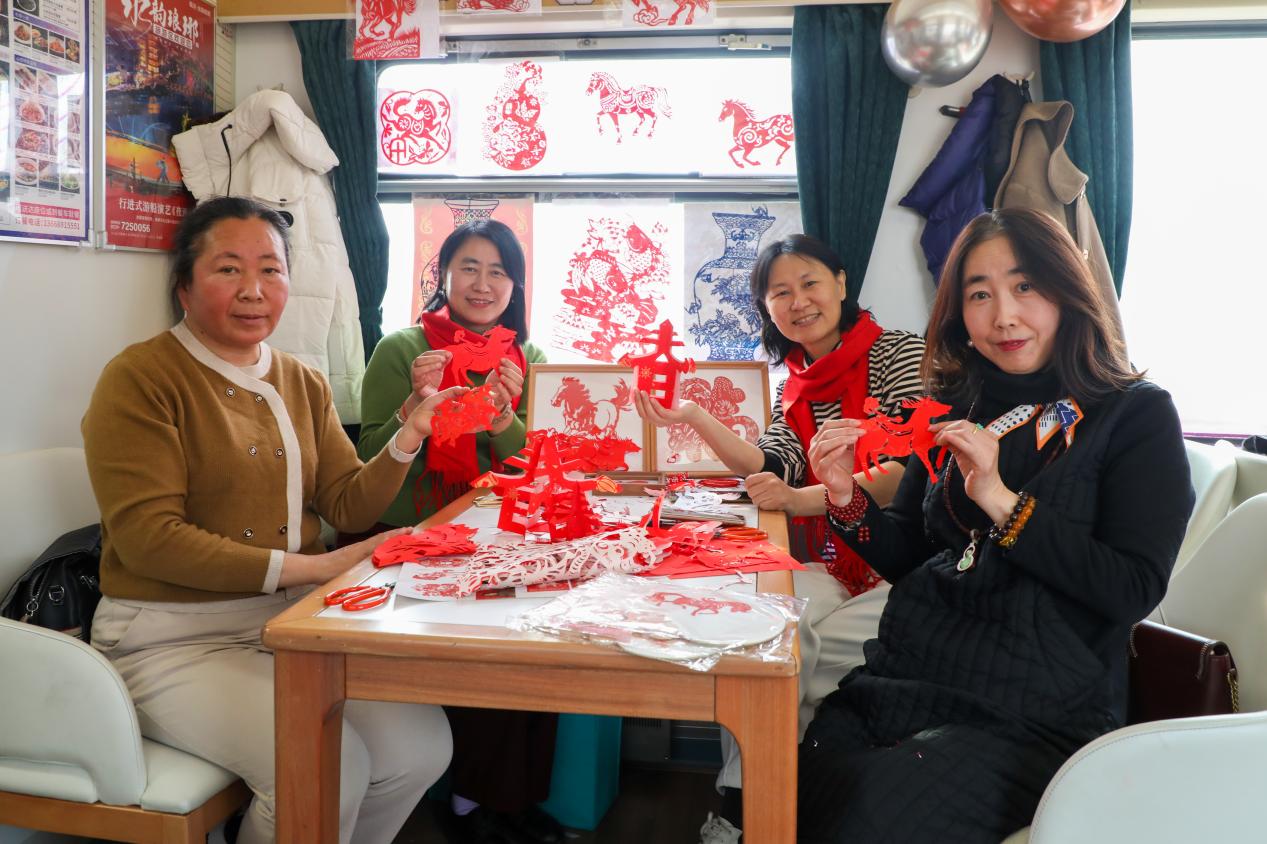1月29日，乘客在“齊魯1號·黃河大集”主題車廂體驗凌氏剪紙。劉洋攝