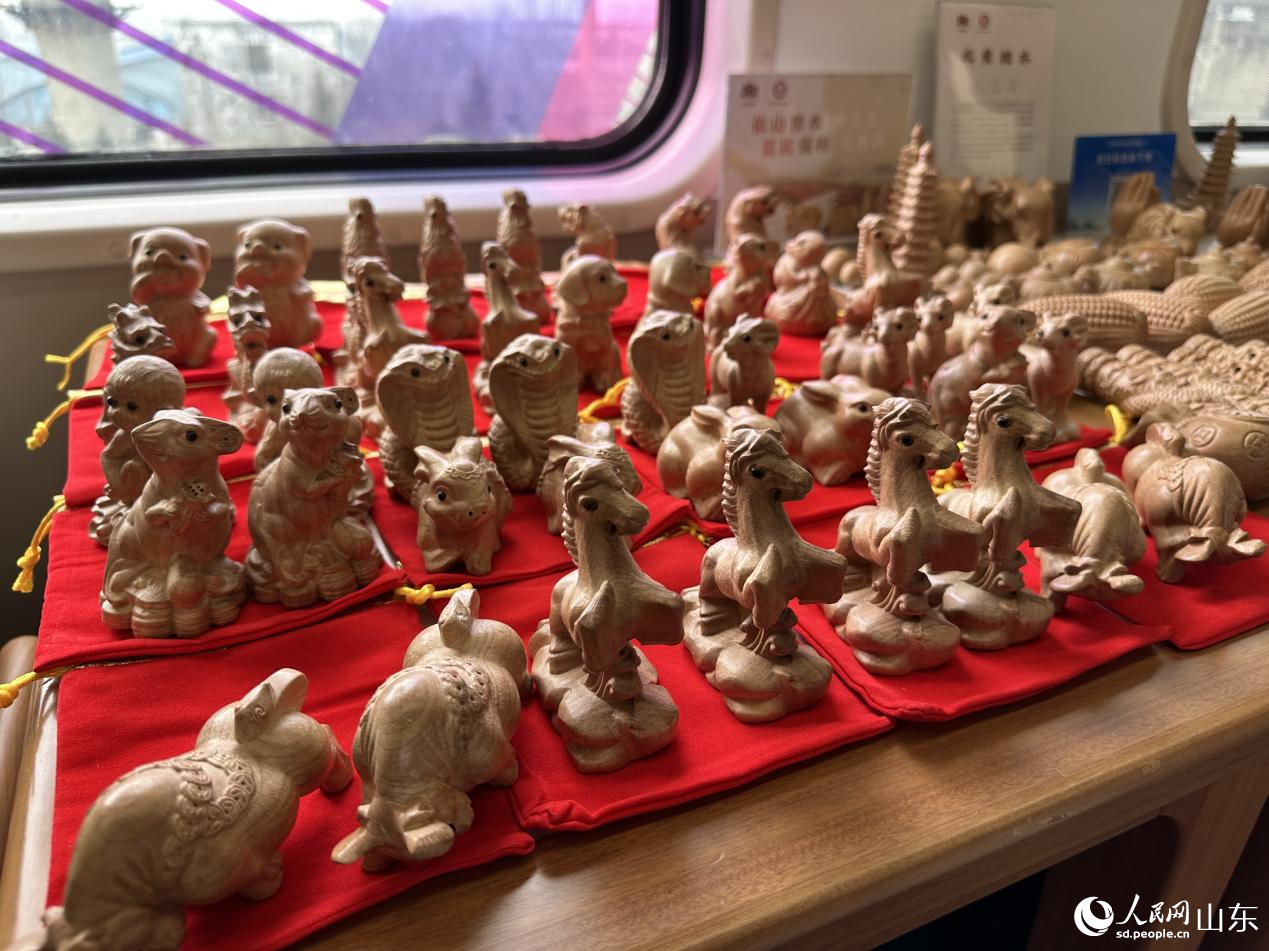 1月29日，在“齊魯1號·黃河大集”主題車廂內展示桃木雕刻工藝品。人民網記者 喬姝攝