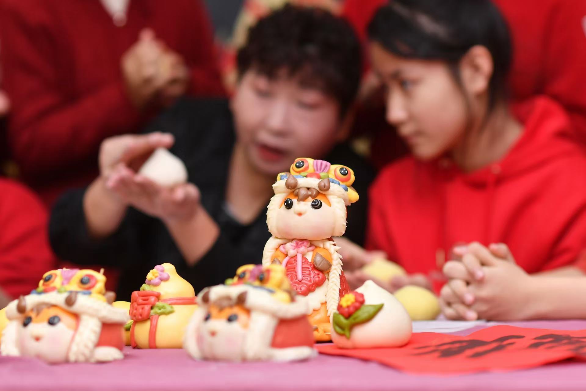 2026年2月2日，在山東省青島市市北區人民路第二小學開展的體驗民俗迎新春主題活動上，老師在指導學生學做花饃。