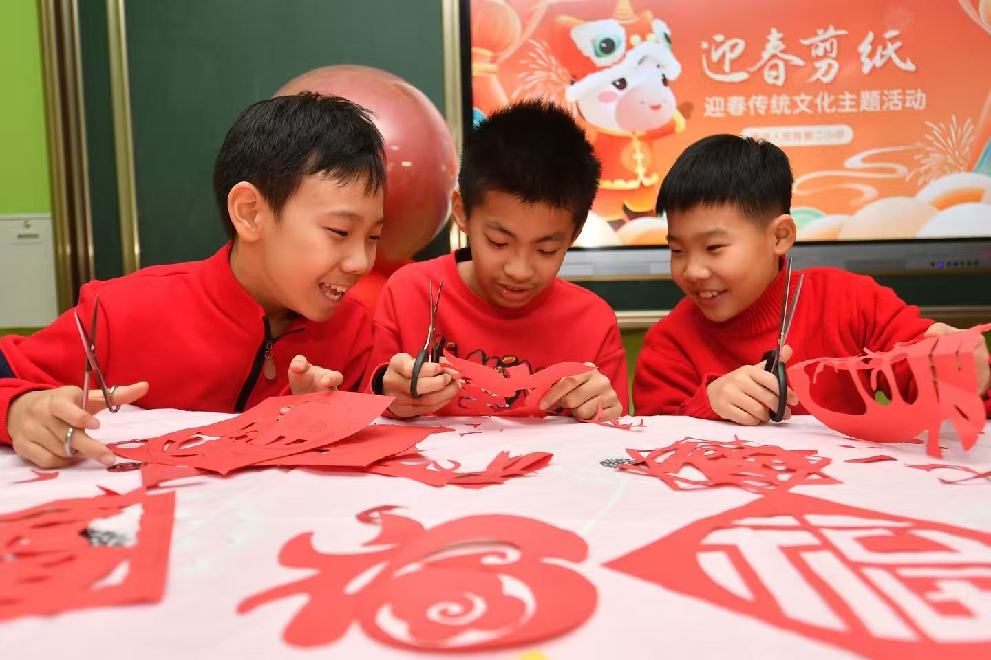 三名學生在學習福字剪紙