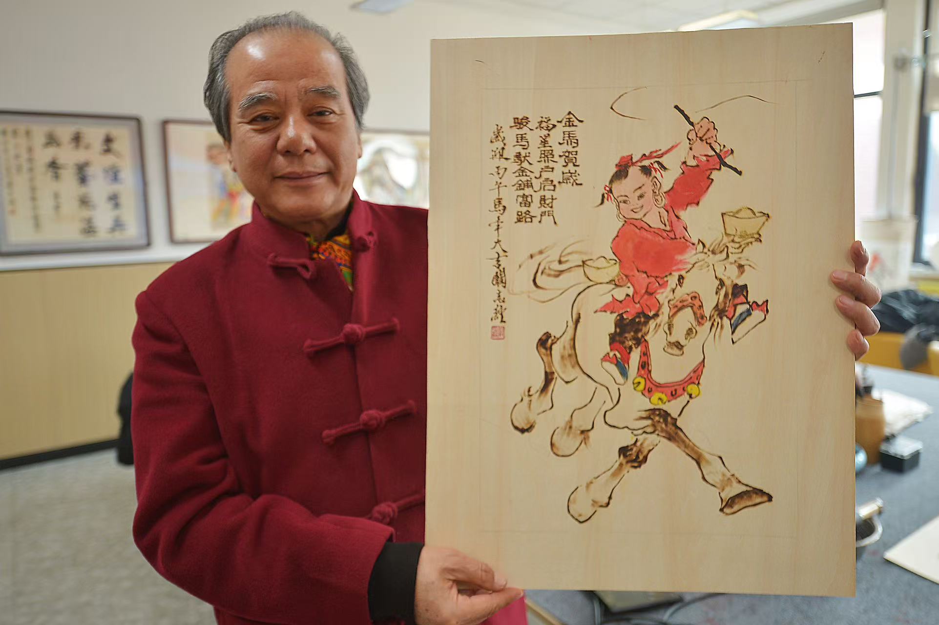 2026年2月5日，在山東省青島市城陽區上馬街道青島培文學校，非遺烙畫傳承人闞志經展示近期創作的《金馬賀歲》烙畫。