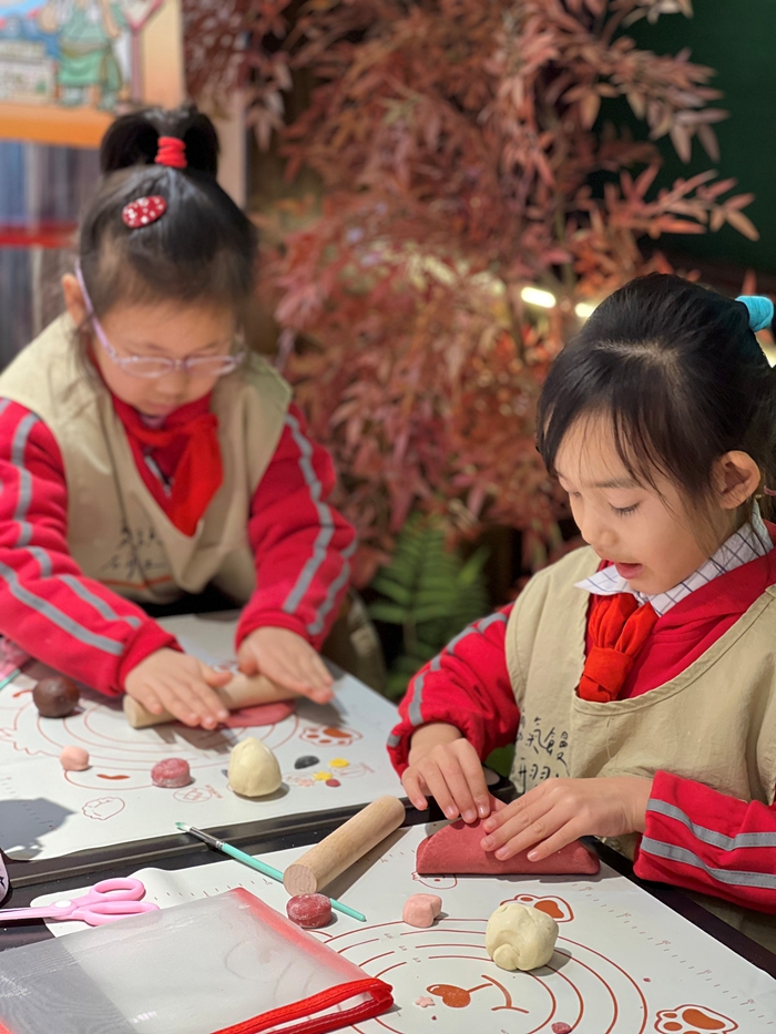 小朋友們正專注地給上好色的面團塑形。王園攝