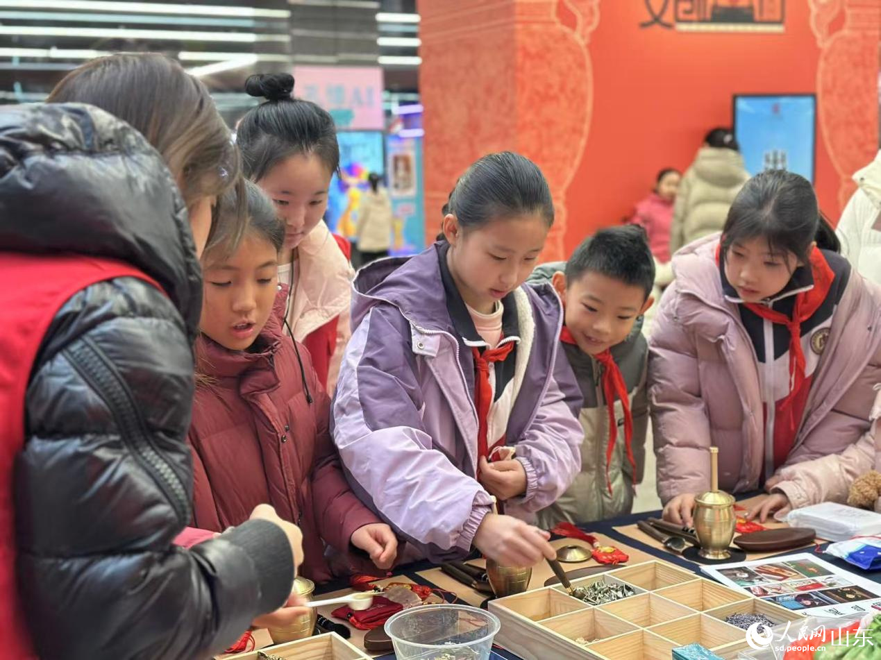 小学生在摊位前体验曲阜香囊制作。人民网记者 乔姝摄