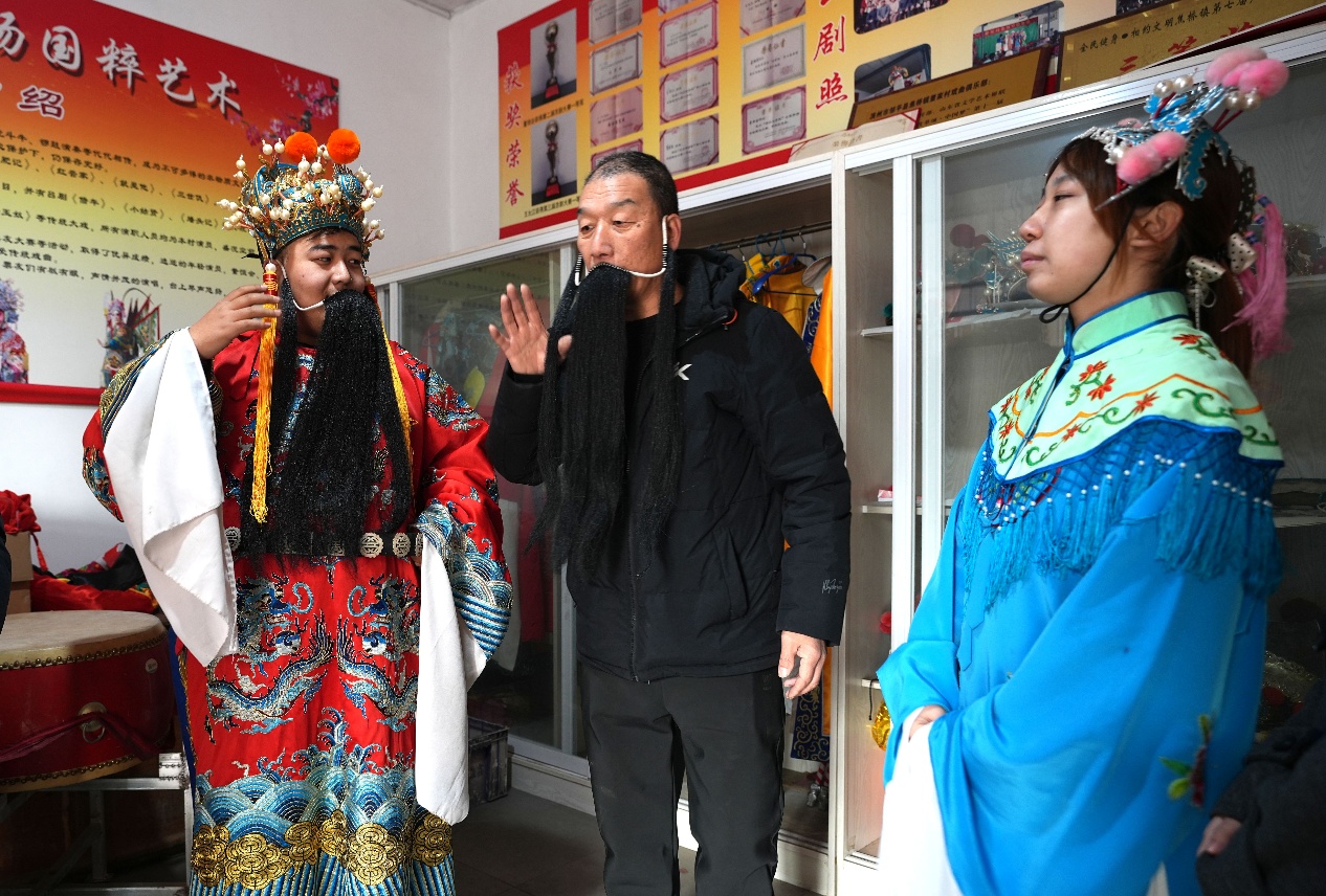 董恆會（中）向董乃元（左）和他的同學傳授京劇相關知識。董乃德攝