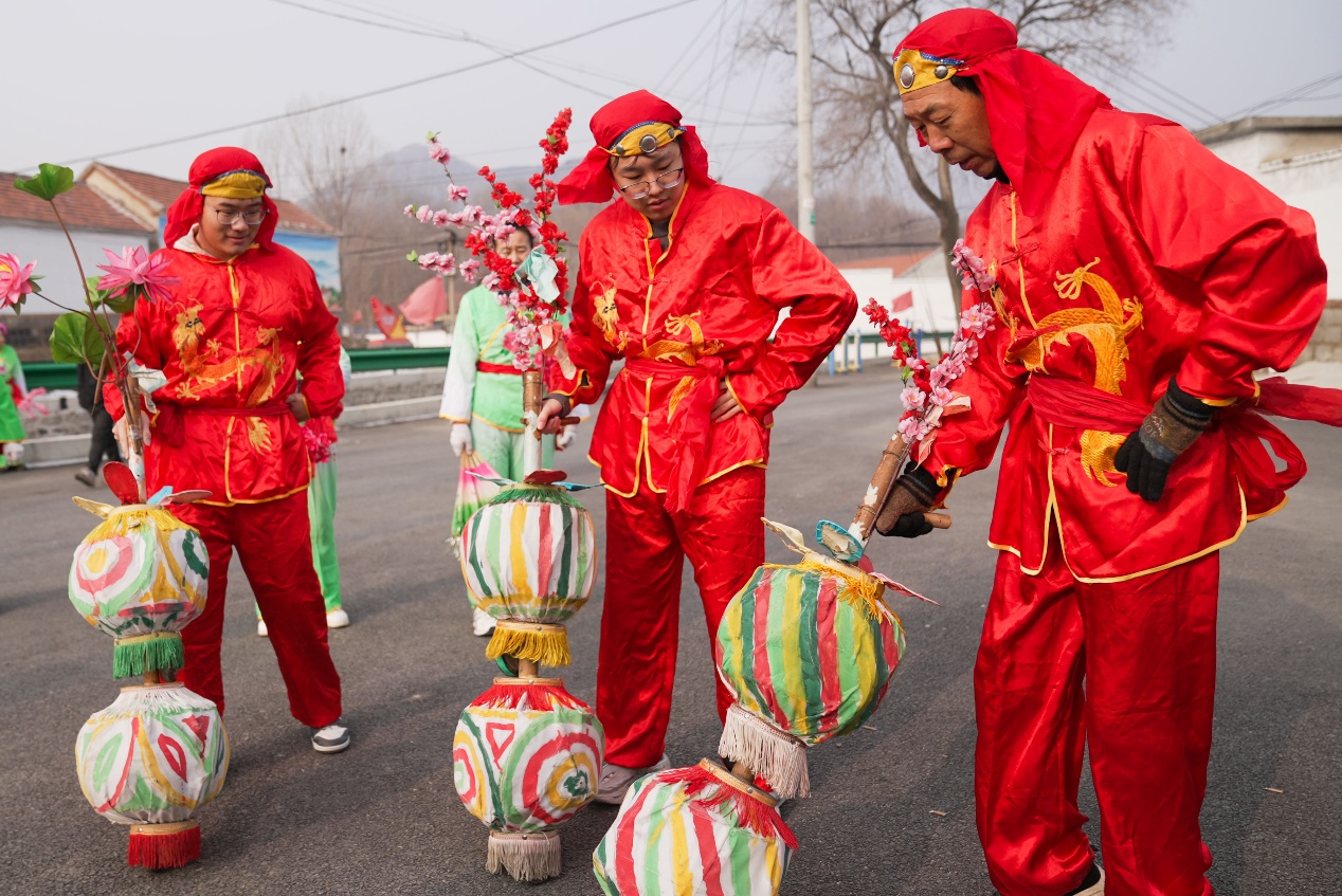西董街道東峪村廣場上，蔡俊毅（左）和胡家程（中）跟著村民學習推車子燈。董乃德攝