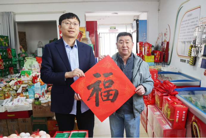 客户经理孙庆鹏为零售户送“福”字