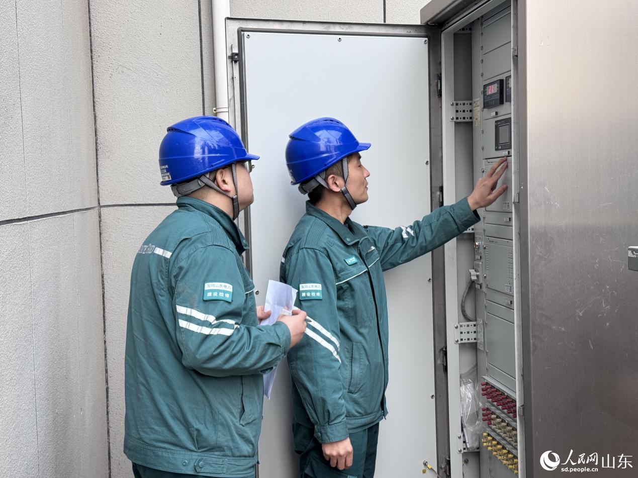 陳銀（右）和同事檢查110kV主變本體智能櫃數據。人民網 鄭昕橋攝