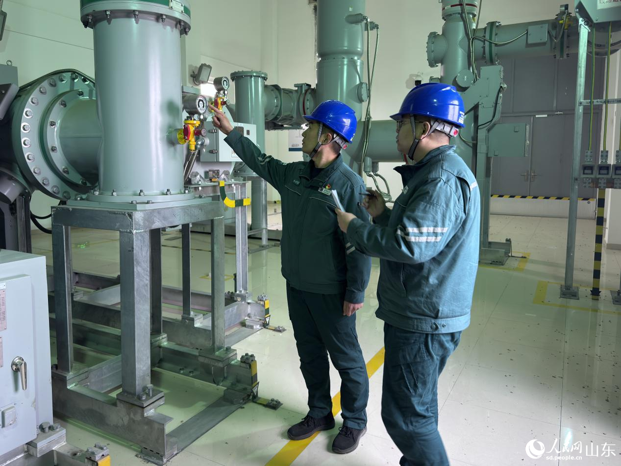 班組成員開展110kVGIS設備巡視，檢查氣室密度表壓力數據。人民網 鄭昕橋攝