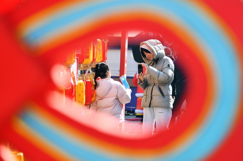 游客在糖球会上拍照游玩。王海斌摄