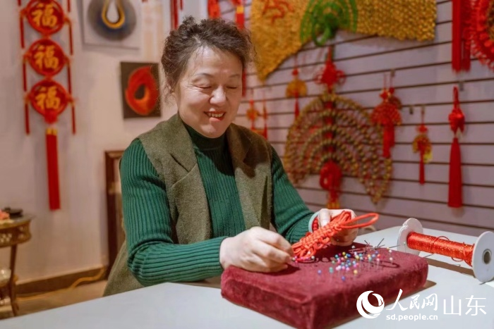 尹崇芹正编织中国结。人民网 陈秋童摄