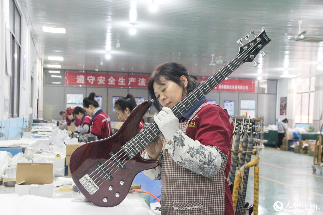 吉他生產車間，一位工人正在給吉他裝配件。人民網記者 宋翠攝