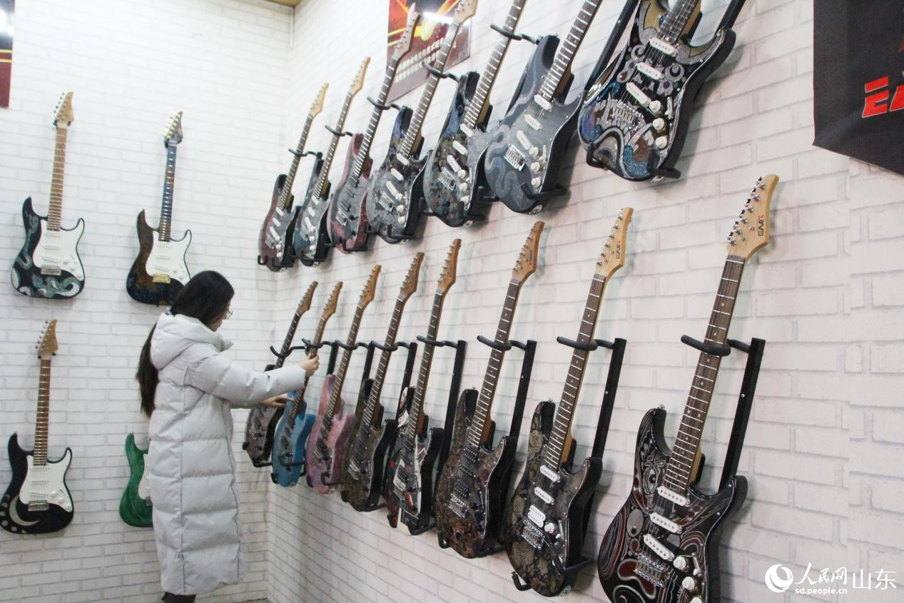 一位顧客正在挑選吉他。人民網記者 宋翠攝