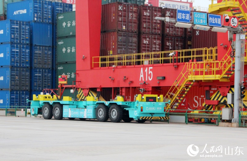 一輛電動智能導引運輸車(IGV)停在軌道吊下等待裝箱。人民網記 宋翠攝