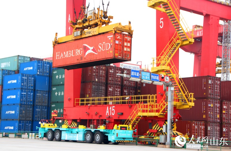 軌道吊將集裝箱吊送到電動智能導引運輸車上。人民網記者 宋翠攝