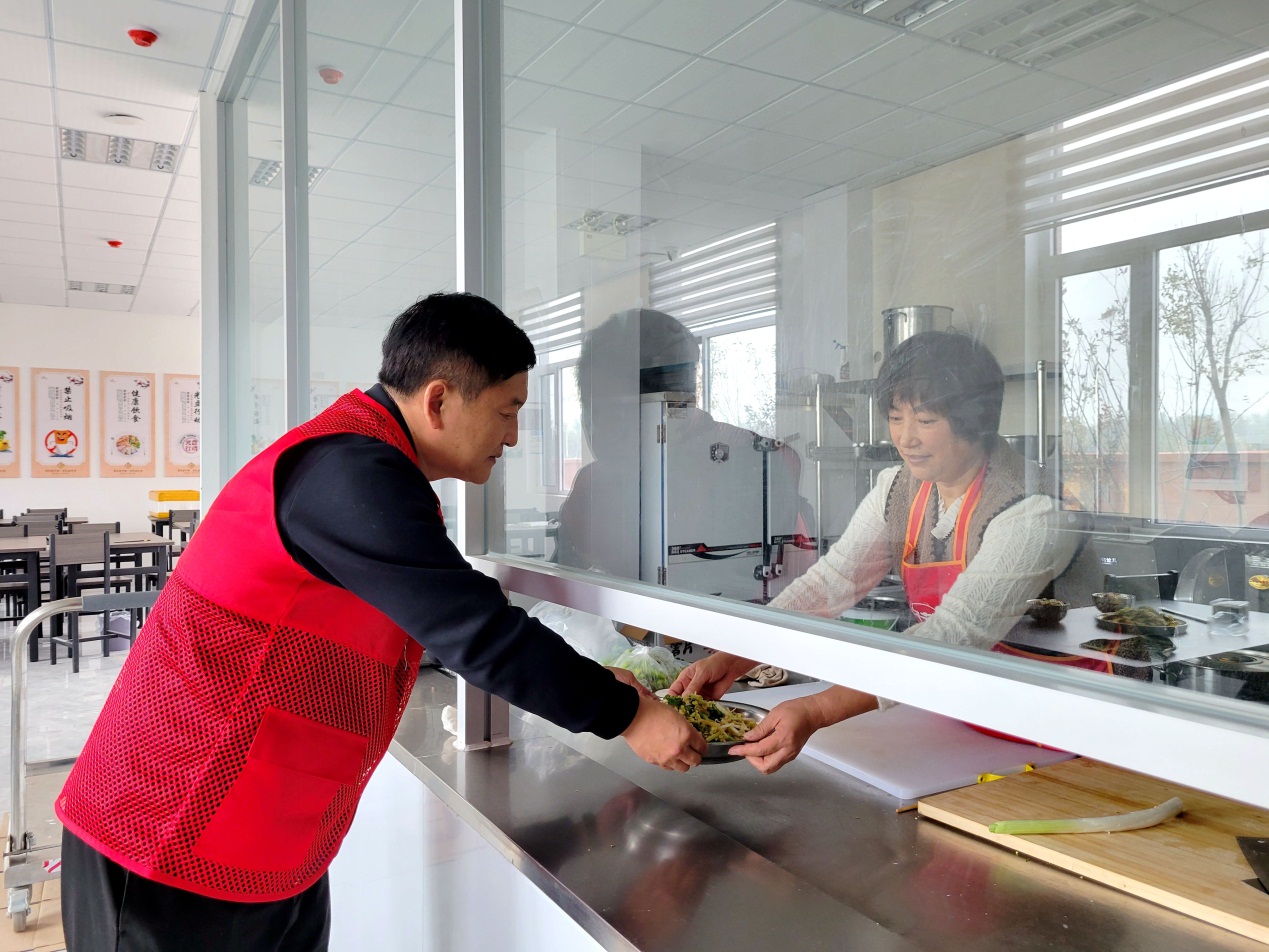 志願者李國軍（左一）為老人准備午餐