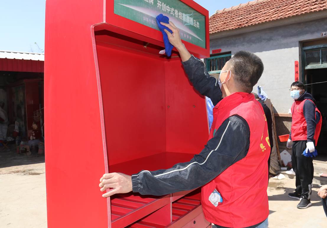 客戶經理劉華偉幫助殘疾零售戶擦拭櫃台