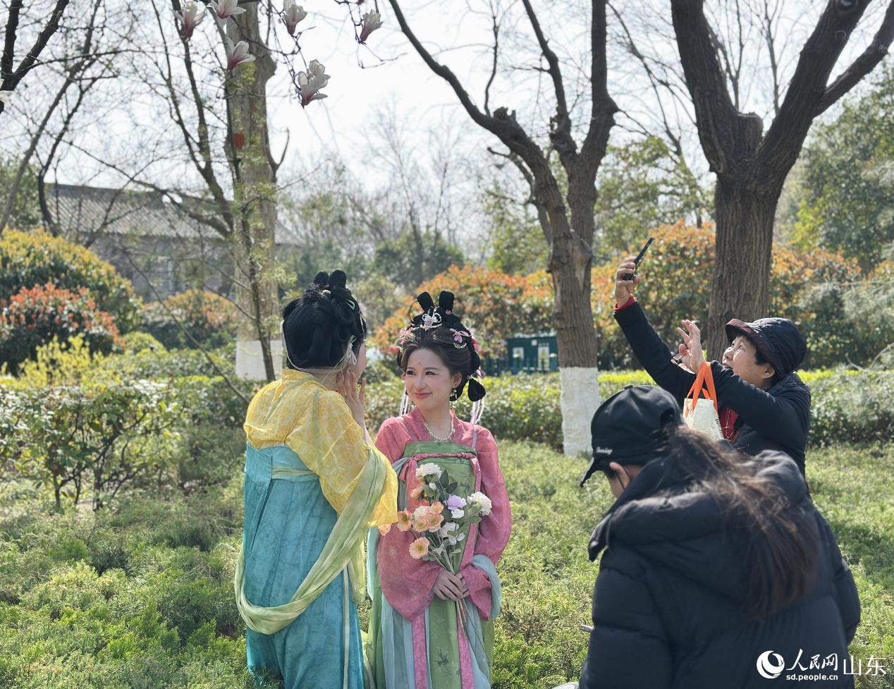 游客身着汉服,在明湖春景中拍照留念。人民网记者 乔姝摄