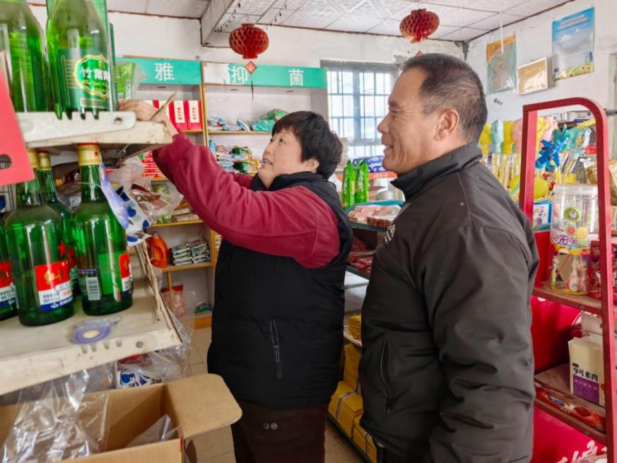 王桂兰帮助困难零售户摆放店内物品