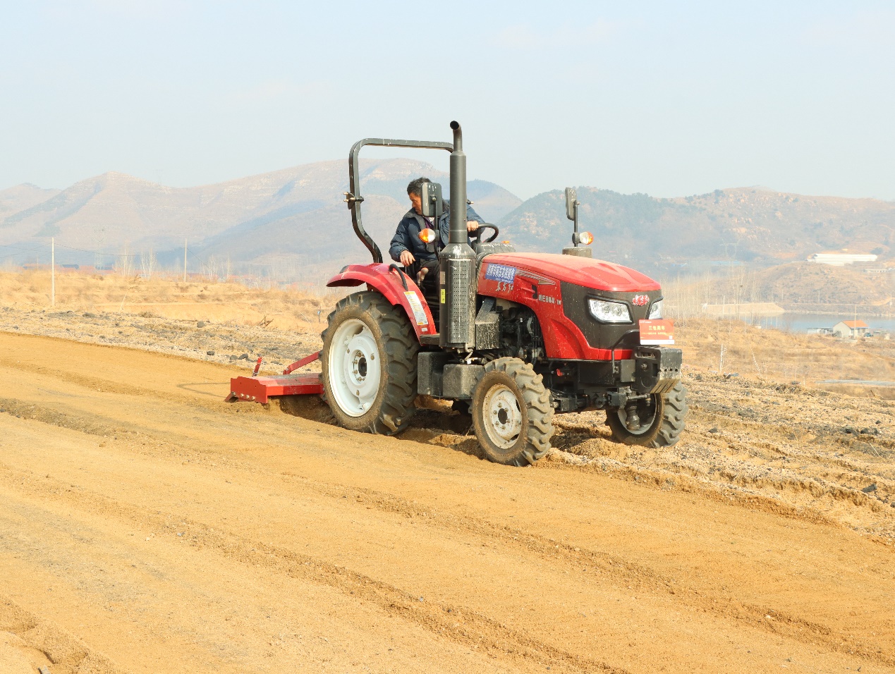 图为开展烟田耙地机械化作业