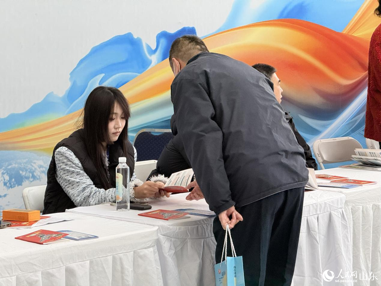 参会人才在咨询处领取大会指引手册。 人民网 李子悦摄