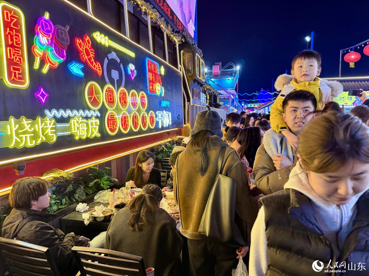 孩子騎在父親肩上觀看英歌舞表演。人民網 鄭昕橋攝