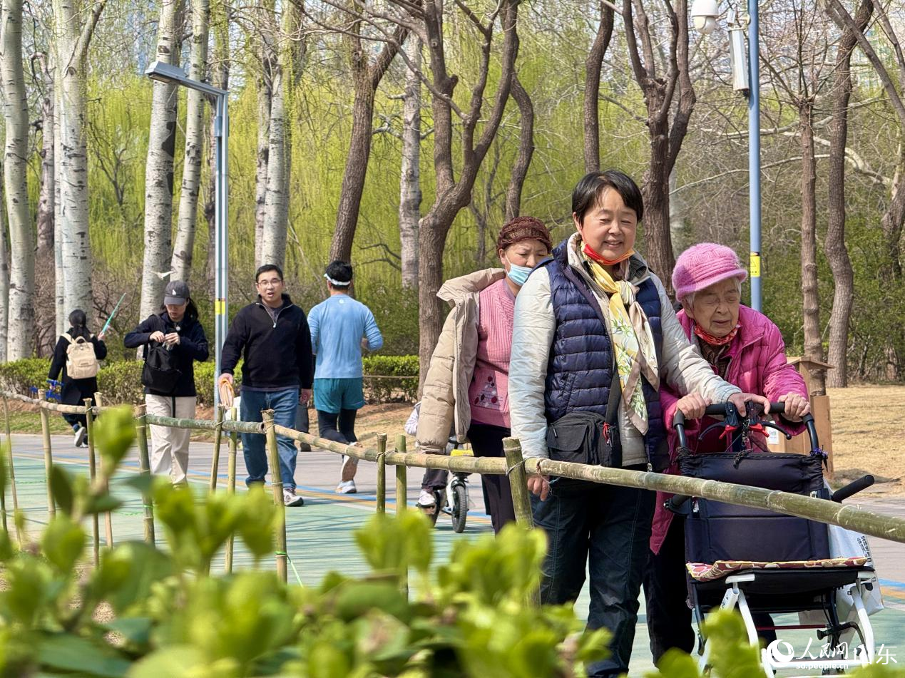 人们走在园间小路上,笑意盈盈。人民网 郑昕桥摄