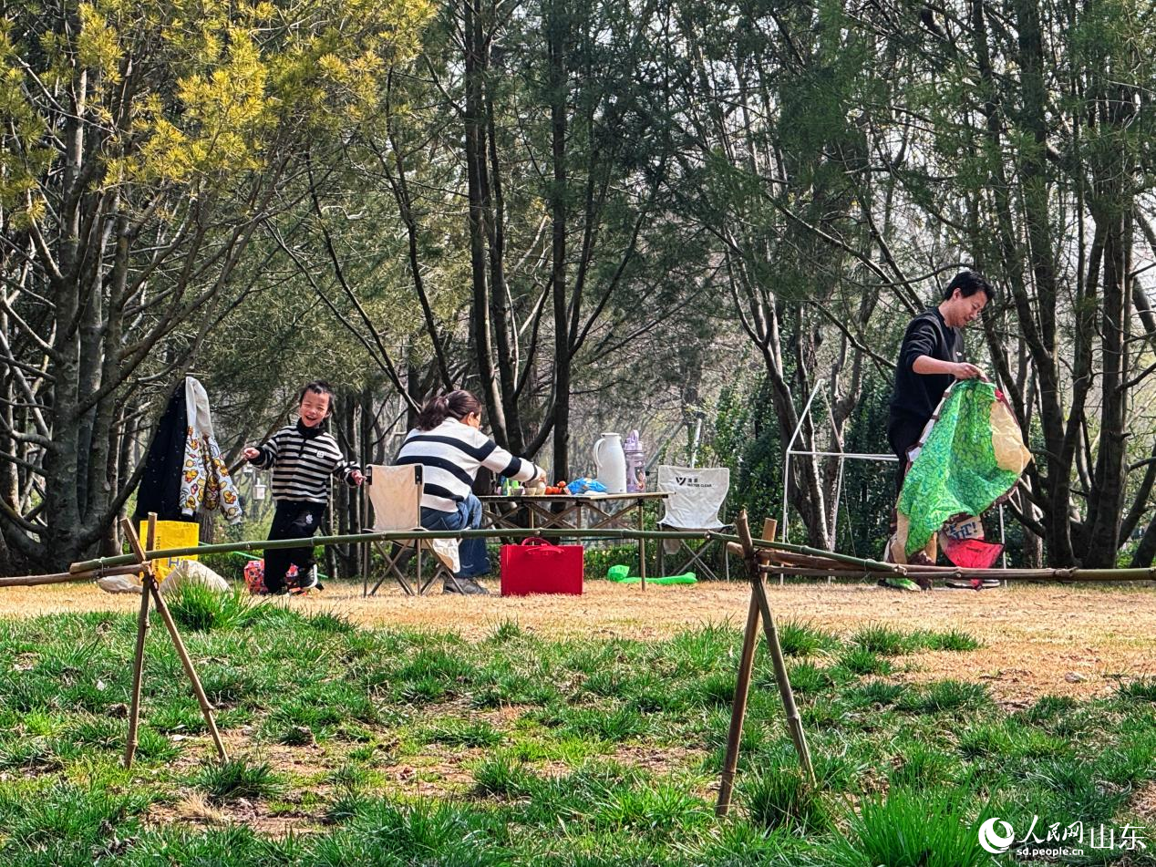 孩子在返青的草坪上笑着奔跑。人民网 郑昕桥摄