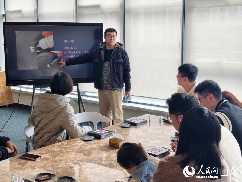 韩晖给市民讲解制作工艺。人民网记者 刘颖婕摄