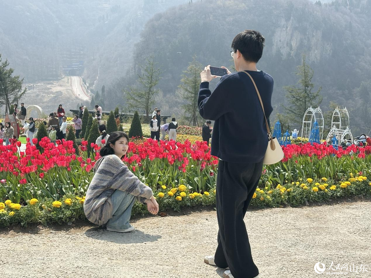游人漫步花间，感受山野间盎然生机。人民网记者 乔姝摄