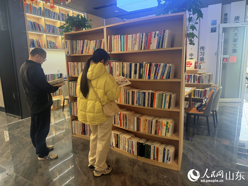 书架前，读者驻足沉浸式翻阅图书。人民网 邢曼华摄