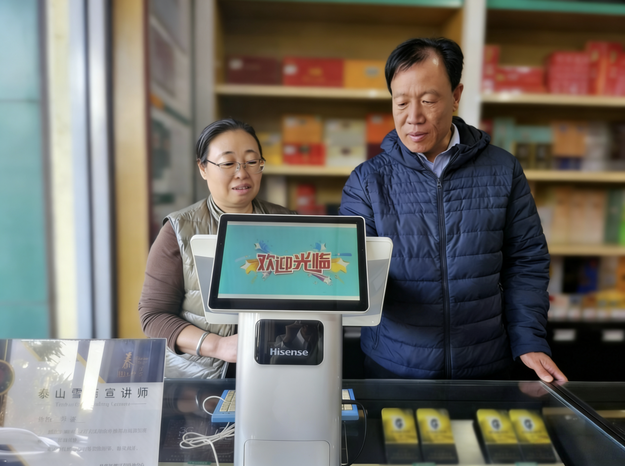 图为烟草客户经理利用职能终端协助客户进行会员数字化管理