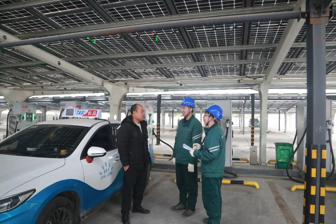 国网山东电力工作人员在淄博新能源三玉社区充电站巡视设备并为电动车主答疑解惑