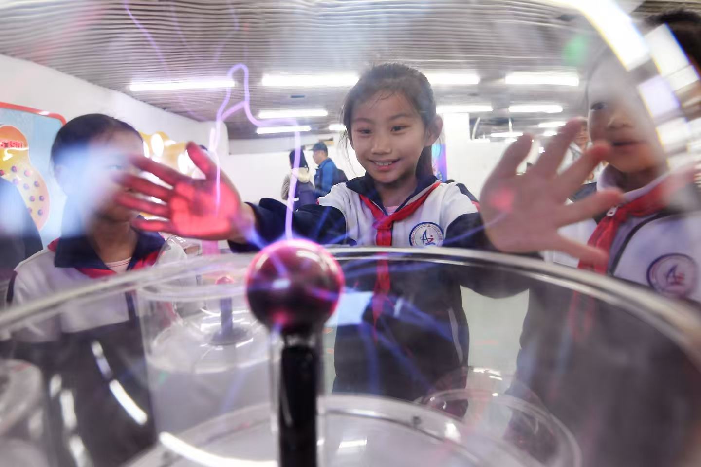 學生們在山東省青島市科技館體驗“輝光球”裝置。