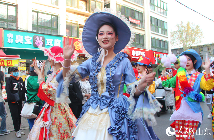 巡游人群身着各色服装，翩翩起舞。人民网记者 宋翠摄