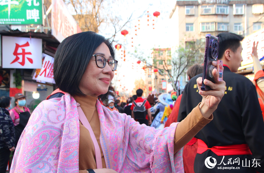 一位大爷手拿相机拍照。人民网记者 宋翠摄