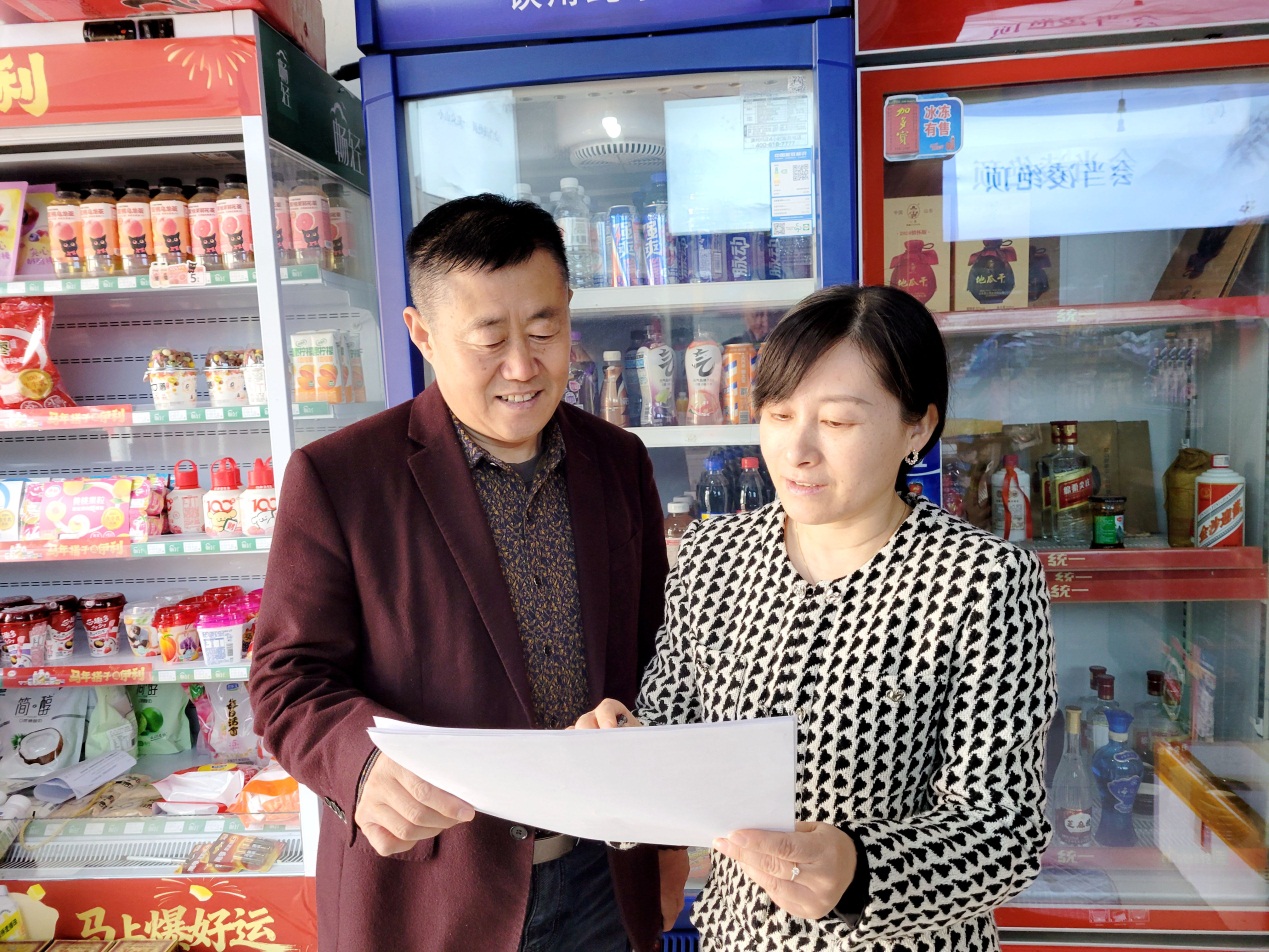 黄在梅(右一)帮助零售户规划店面布局