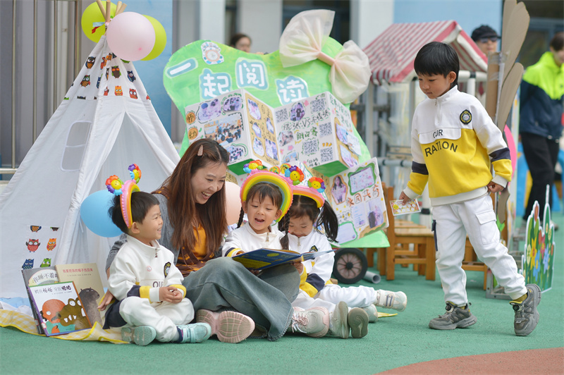 2026年4月23日，在山东省青岛市市北区宝城幼儿园开展的读书主题活动上，小朋友与老师分享图书故事。王海滨摄