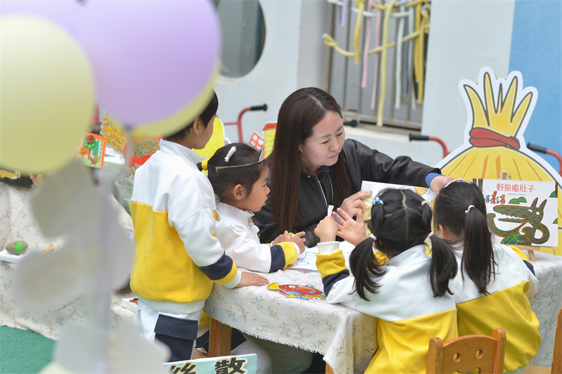 2026年4月23日，在山东省青岛市市北区宝城幼儿园开展的读书主题活动上，家长陪伴小朋友们阅读。王海滨摄