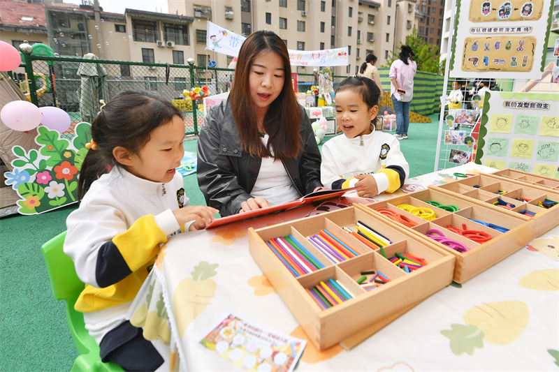 2026年4月23日，在山东省青岛市市北区宝城幼儿园开展的读书主题活动上，家长陪伴小朋友们阅读。王海滨摄
