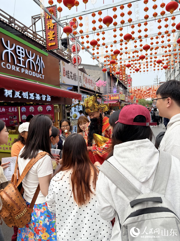 八大局便民市场内，店铺工作人员以角色演绎的方式与游客互动。 人民网 李子悦摄