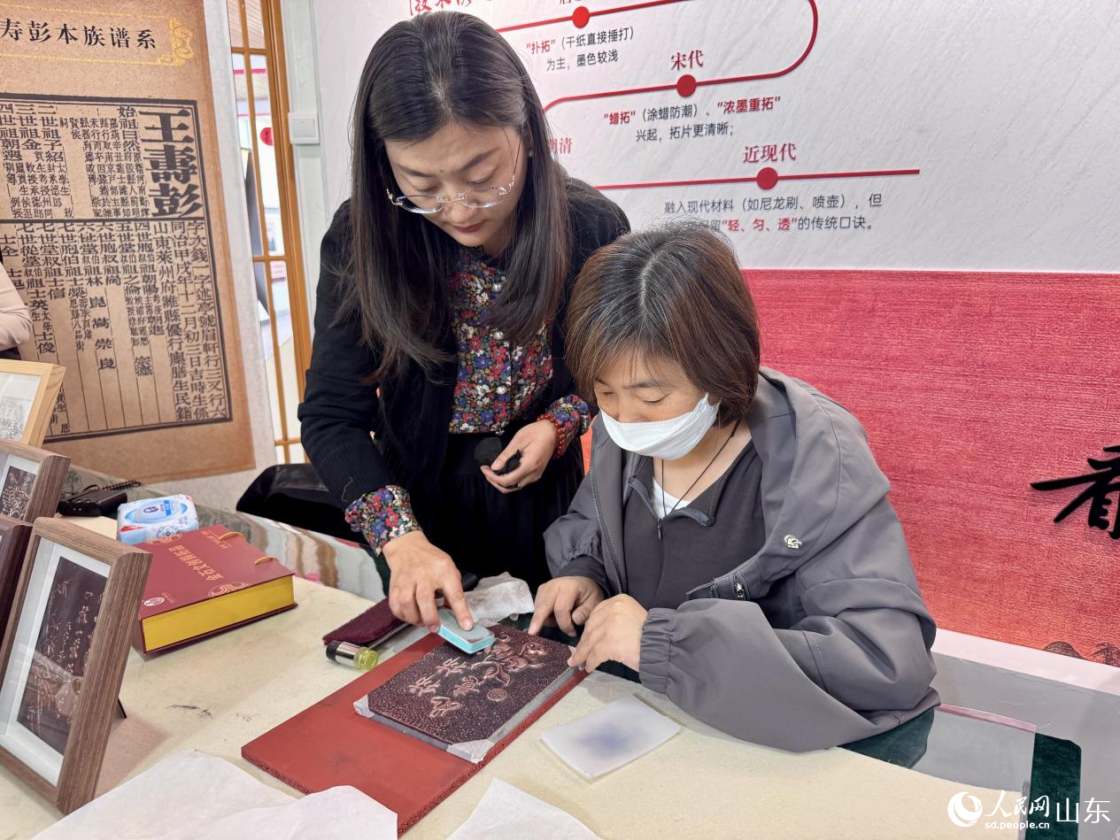 社区居民正在学习铜拓画。人民网 郑昕桥摄