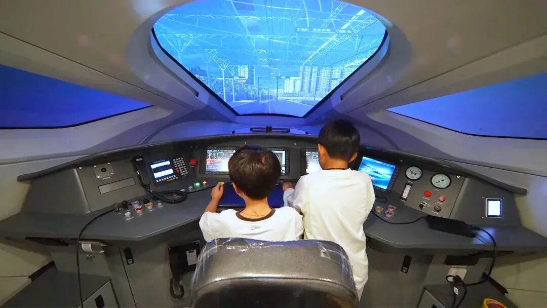孩子们在中车四方文化科技馆里模拟驾驶高铁