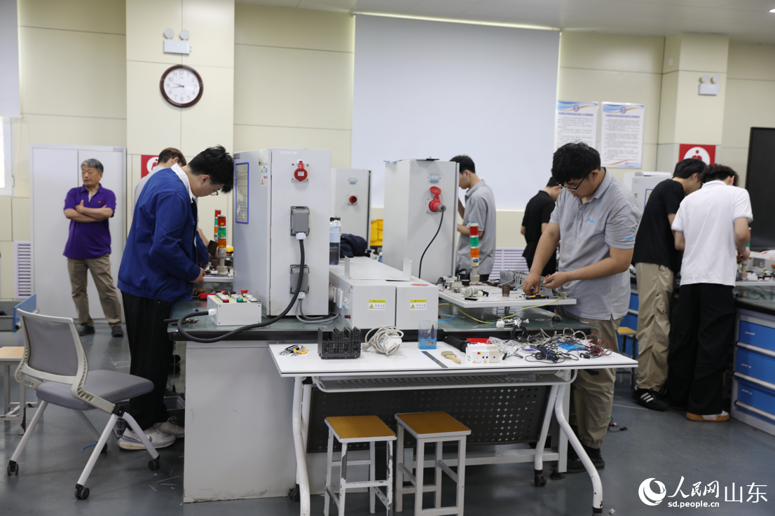 济南职业学院观摩现场，学生们正在测试设备。人民网记者 刘祺摄