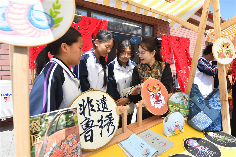 2026年5月15日，学生在山东省青岛市城阳区职教中心学校举办的科技文化节成果展示活动上学习鲁绣技艺。王海滨摄