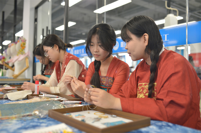 2026年5月15日，学生在山东省青岛市城阳区职教中心学校举办的科技文化节成果展示活动上手工制作压襟饰品。王海滨摄