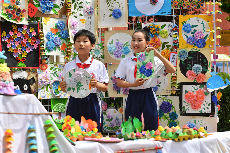2026年5月21日，在山東省青島市舉辦的“紅領巾愛自然”生物多樣性科普教育活動上，大北曲小學的學生展示各式手工花卉。