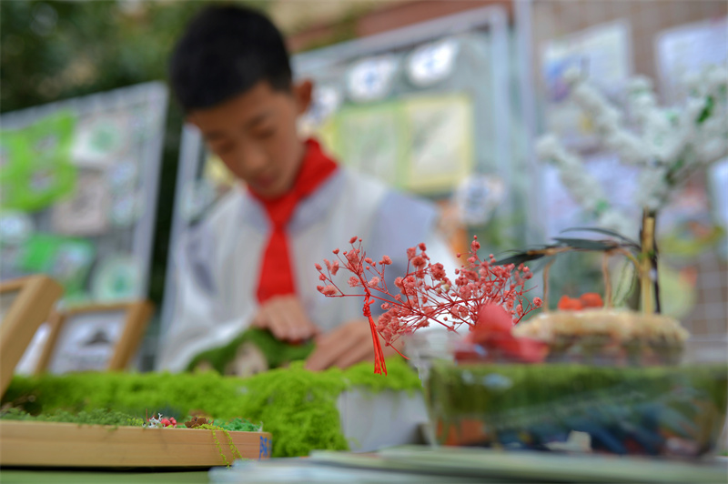 2026年5月21日，在山東省青島市舉辦的“紅領巾愛自然”生物多樣性科普教育活動上，三台小學的學生布置流蘇文創展台。